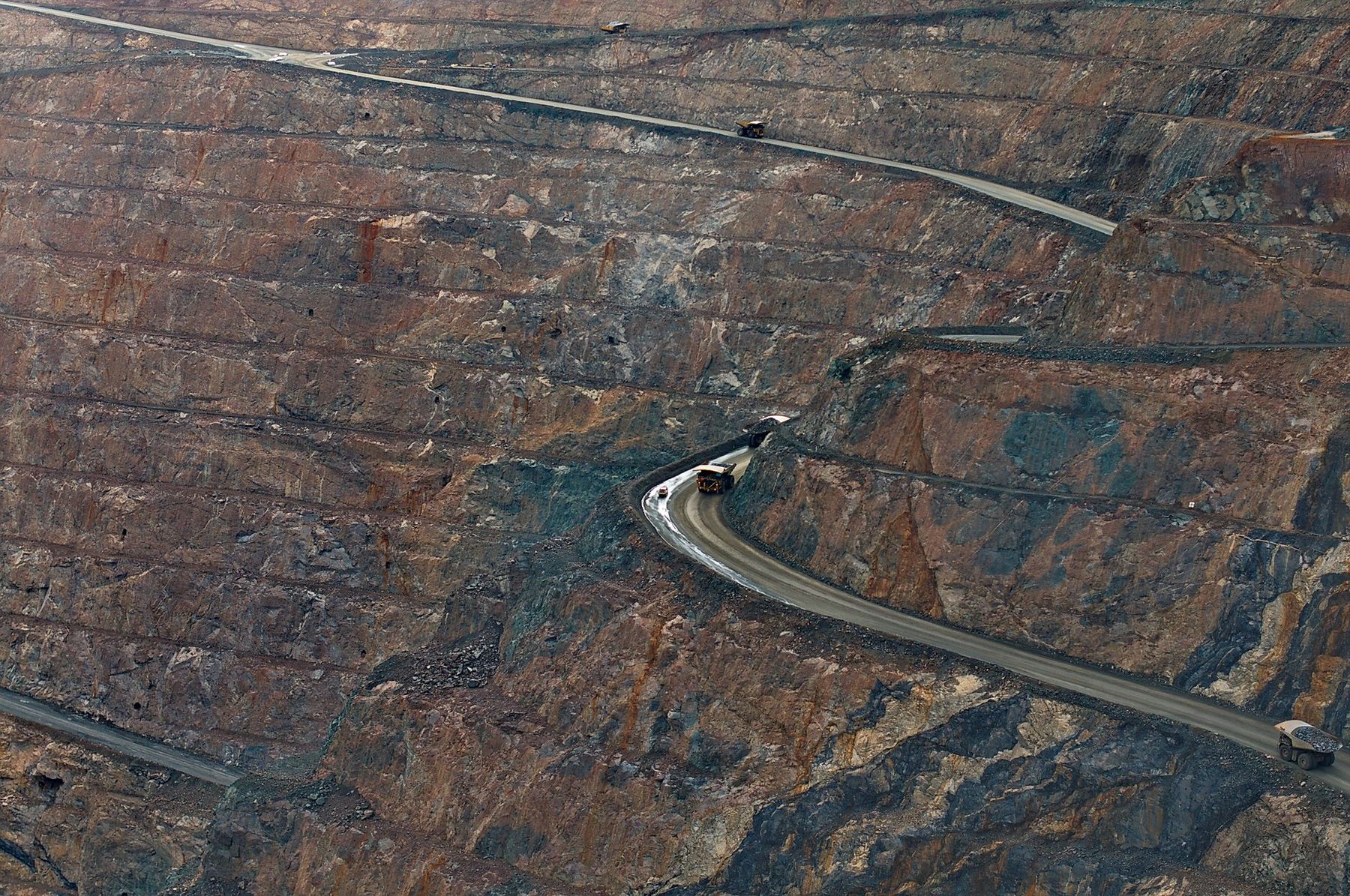 Mine à ciel ouvert avec camions industriels transportant du minerai